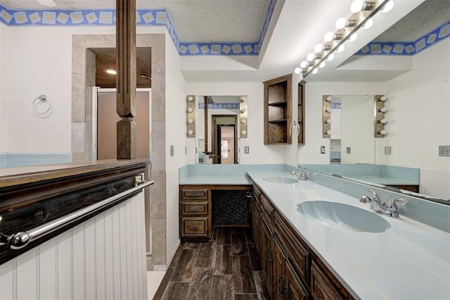 1113 Bank Side Cir, Edmond, OK 73012 - bathroom with wood finished floors, a sink, double vanity, and tiled shower