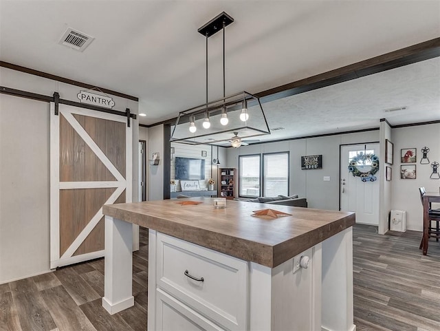 28737 Oakwood Meadows Dr, Cashion, OK 73016 - kitchen featuring butcher block countertops, dark wood-style floors, white cabinetry, a barn door, and visible vents