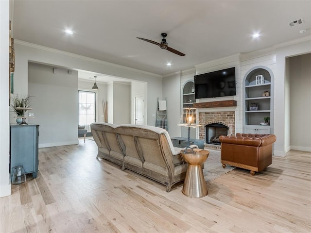 living area featuring crown molding, a ceiling fan, and light wood-style floors
