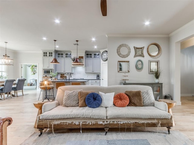living area featuring recessed lighting, ornamental molding, light wood finished floors, and a ceiling fan