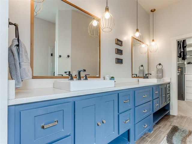 full bathroom featuring double vanity, a sink, and wood finish floors