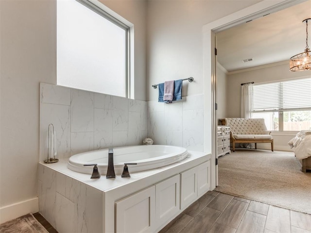 bathroom with crown molding, a chandelier, baseboards, visible vents, and a bath