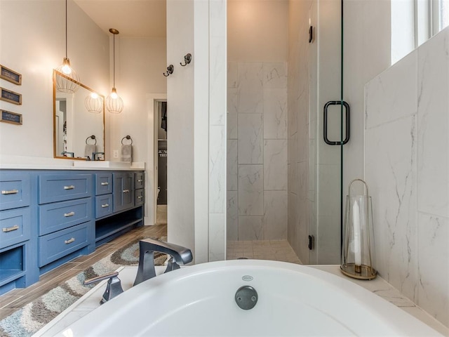 full bath featuring vanity, a bathtub, and a stall shower