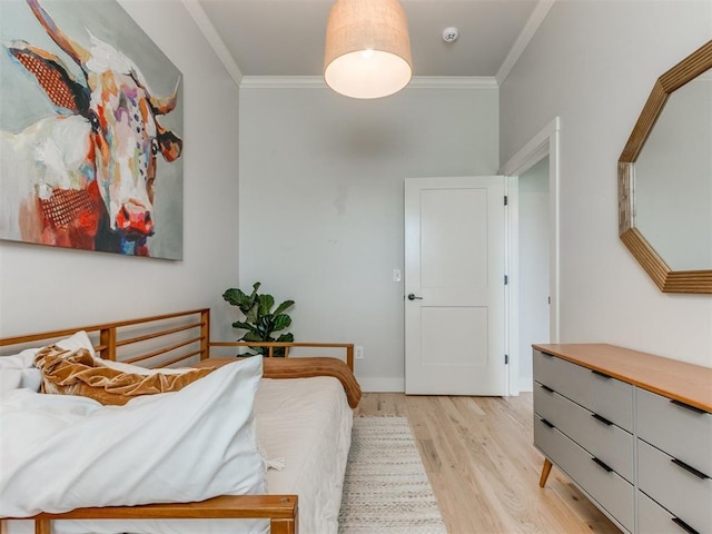 bedroom with crown molding, baseboards, and light wood-style floors