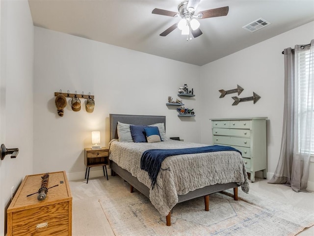 bedroom featuring visible vents, light carpet, baseboards, ceiling fan, and multiple windows