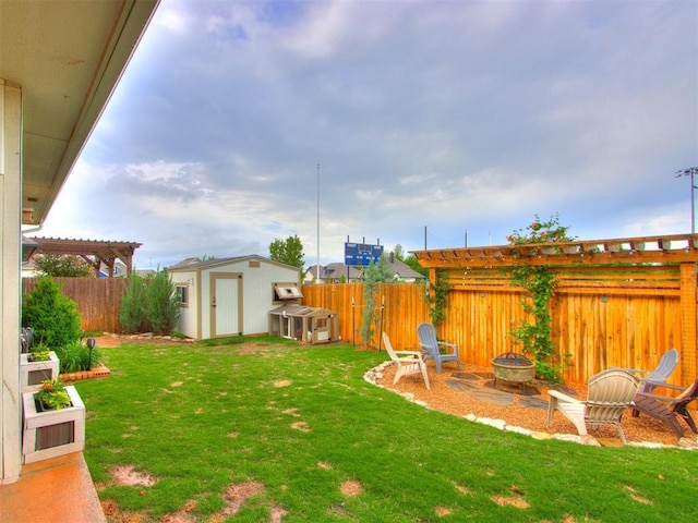 view of yard featuring a fenced backyard, an outdoor fire pit, a shed, and an outbuilding