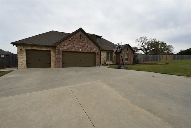 view of front of house with a garage, fence, a front lawn, a shingled roof, and driveway