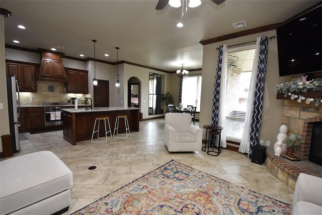 living room with visible vents, baseboards, crown molding, recessed lighting, and ceiling fan with notable chandelier