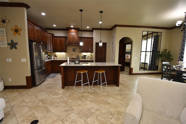 kitchen featuring arched walkways, ornamental molding, stainless steel refrigerator with ice dispenser, decorative backsplash, and baseboards