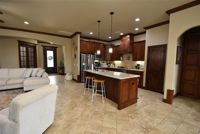 kitchen featuring crown molding, stainless steel appliances, backsplash, and arched walkways