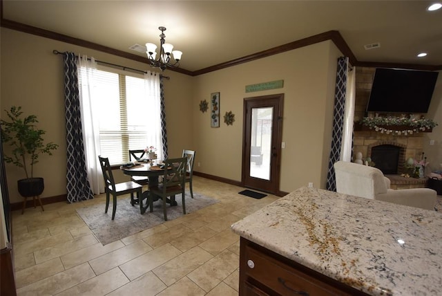 dining area featuring crown molding, light tile patterned floors, a fireplace with raised hearth, a chandelier, and baseboards
