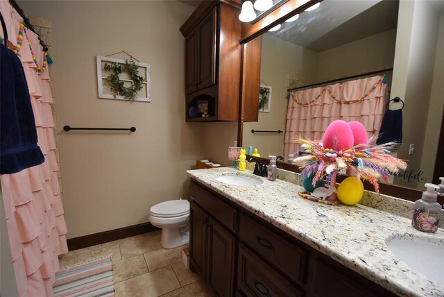 full bathroom featuring a sink, toilet, double vanity, and tile patterned flooring