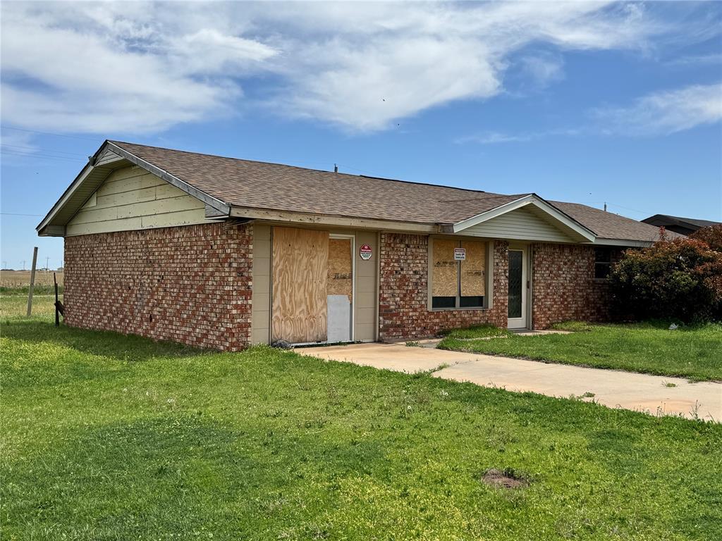 414 S Highland Ave, Hobart, OK 73651 - ranch-style home with a shingled roof, a front yard, and brick siding