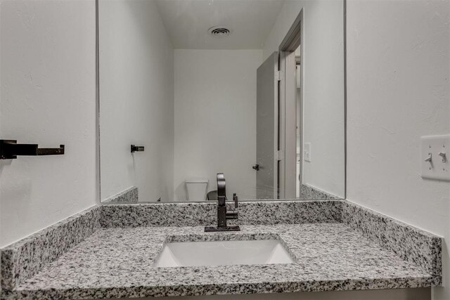 2621 NW 121st St, Oklahoma City, OK 73120 - half bathroom with visible vents, vanity, and toilet
