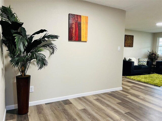 hallway with wood finished floors and baseboards