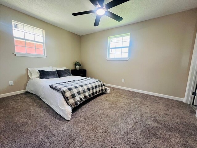 bedroom featuring carpet floors, a textured ceiling, baseboards, and ceiling fan