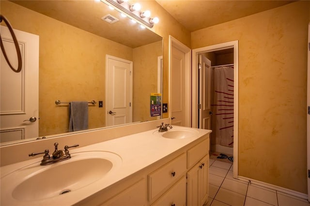 bathroom with tile patterned floors, a sink, visible vents, and double vanity