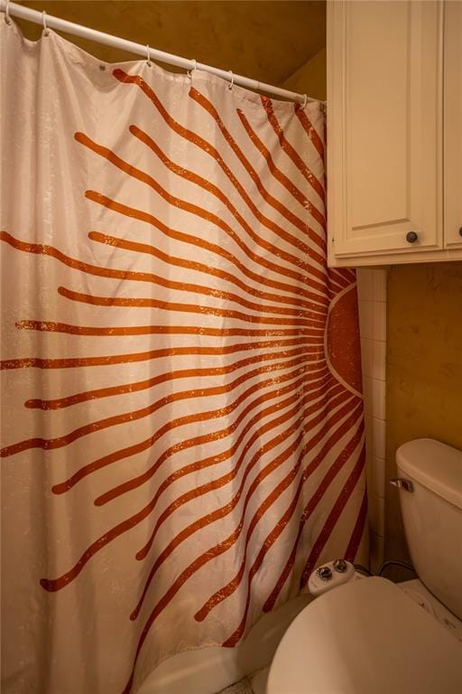 full bathroom with a shower with shower curtain and toilet