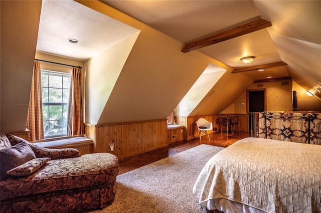 bedroom with lofted ceiling, wood finished floors, a wainscoted wall, and wood walls