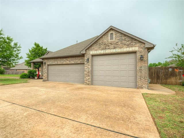 view of front of home with a garage, fence, brick siding, a shingled roof, and driveway