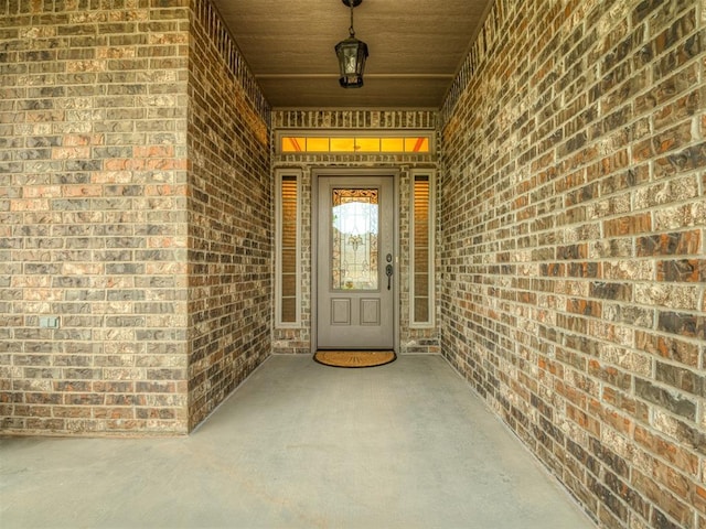 view of exterior entry with brick siding