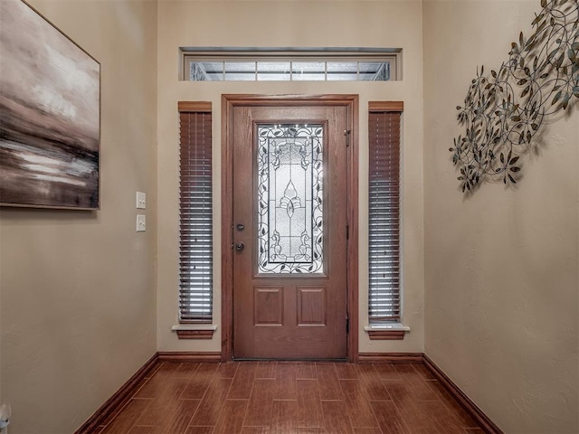 entryway featuring baseboards and dark wood-type flooring