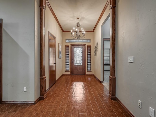 foyer entrance with crown molding, baseboards, an inviting chandelier, and dark wood-style floors