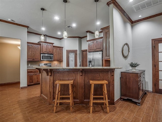kitchen with crown molding, visible vents, and stainless steel appliances