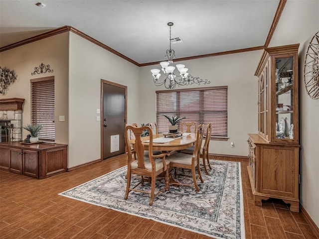 dining space featuring baseboards, ornamental molding, wood finished floors, and a chandelier