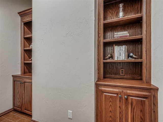 details featuring baseboards, a textured wall, and wood finished floors