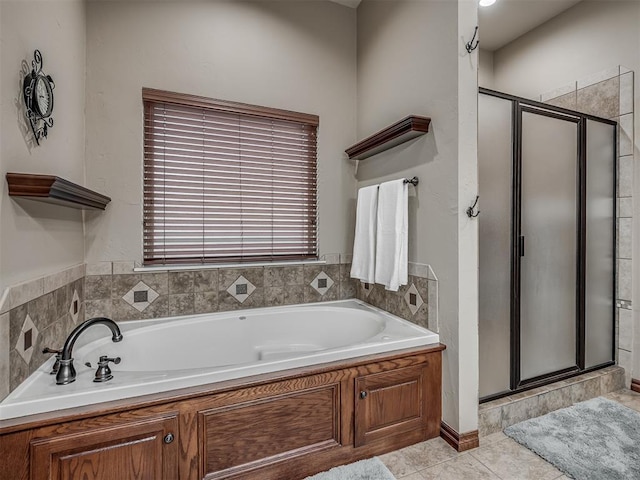 bathroom with tile patterned floors, a stall shower, and a garden tub