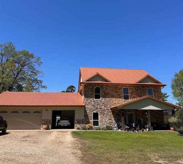 view of front facade featuring driveway, stone siding, a front yard, and a garage