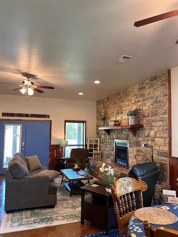living area with plenty of natural light, visible vents, and ceiling fan