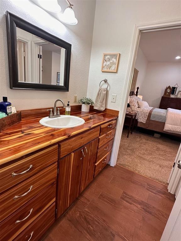 bathroom featuring wood finished floors, vanity, and connected bathroom