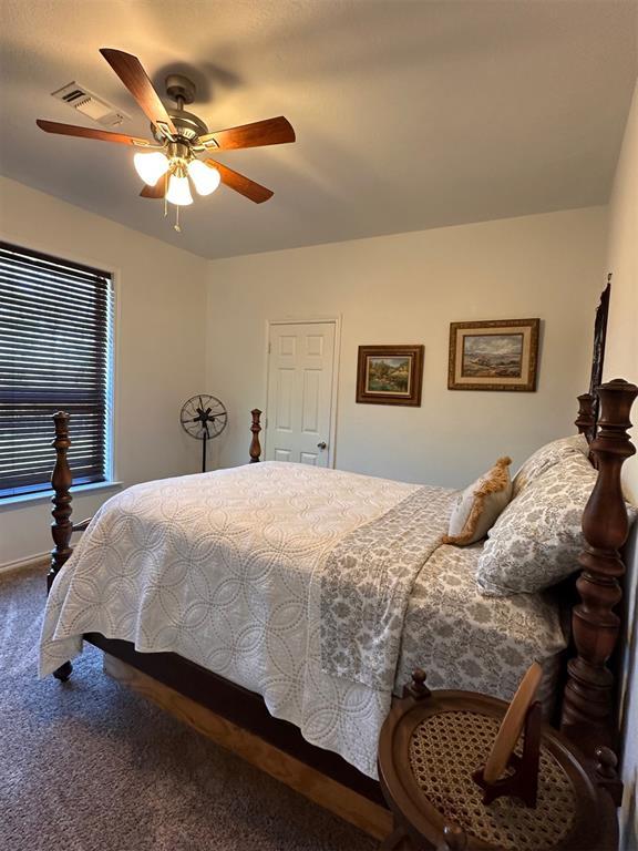 bedroom with visible vents, ceiling fan, and carpet floors