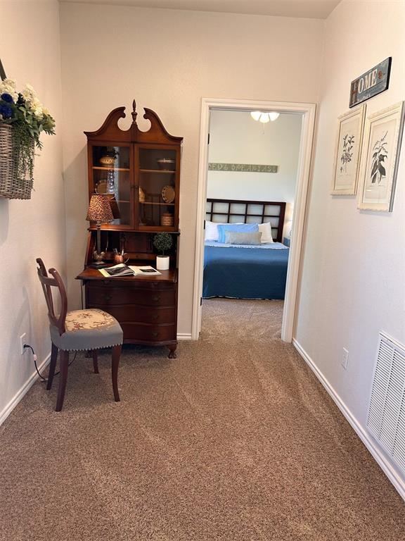 office featuring carpet floors, baseboards, and visible vents