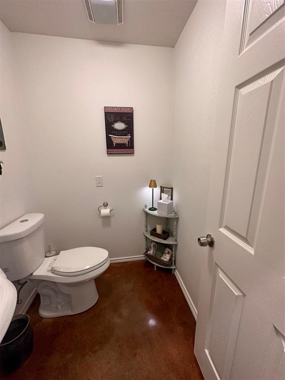 bathroom featuring visible vents, baseboards, and toilet