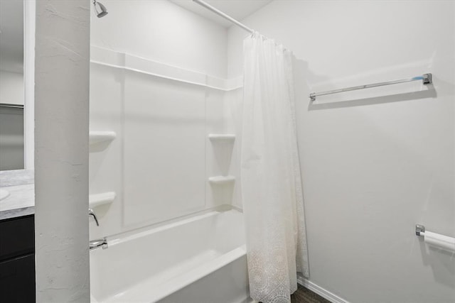 full bath featuring baseboards, shower / tub combo, and vanity