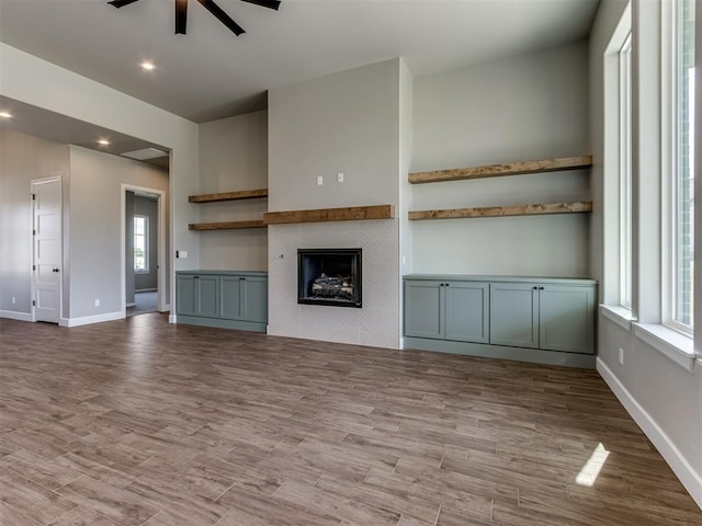 15528 NE 36th St, Choctaw, OK 73020 - unfurnished living room with baseboards, a ceiling fan, wood finished floors, and a fireplace