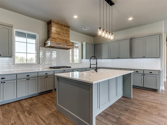 15528 NE 36th St, Choctaw, OK 73020 - kitchen with gas cooktop, a sink, visible vents, gray cabinetry, and premium range hood