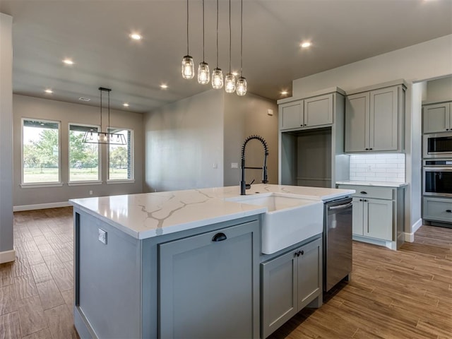 15528 NE 36th St, Choctaw, OK 73020 - kitchen featuring tasteful backsplash, a sink, gray cabinets, a center island with sink, and appliances with stainless steel finishes