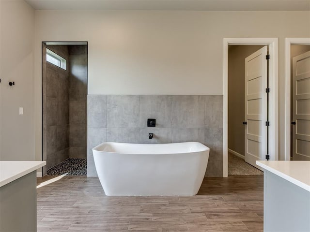 15528 NE 36th St, Choctaw, OK 73020 - bathroom featuring a freestanding bath, tile walls, vanity, and wood finished floors