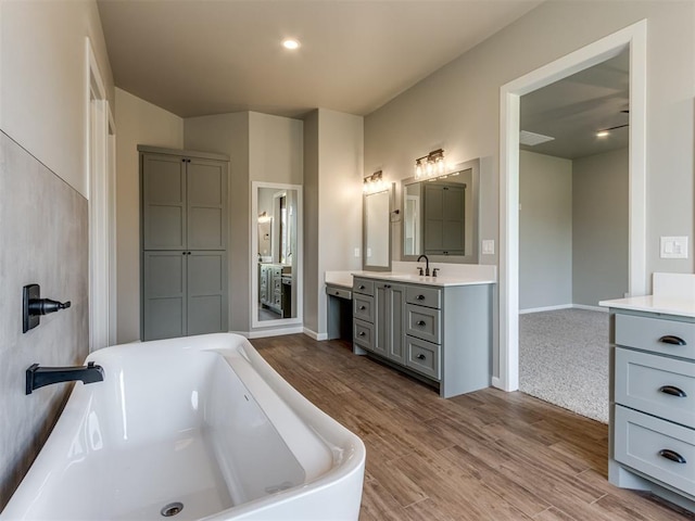 15528 NE 36th St, Choctaw, OK 73020 - full bathroom with a soaking tub, baseboards, wood finished floors, and vanity