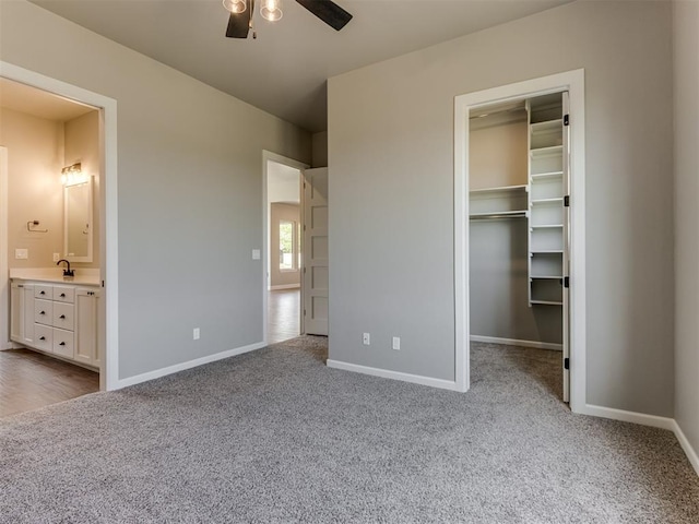 15528 NE 36th St, Choctaw, OK 73020 - unfurnished bedroom with a walk in closet, carpet, baseboards, and a sink