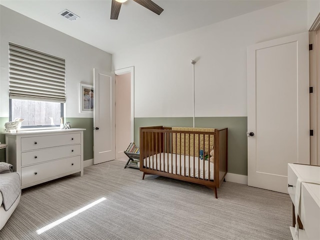 2320 Belleview Dr, Oklahoma City, OK 73112 - bedroom with visible vents, baseboards, a ceiling fan, a crib, and light colored carpet