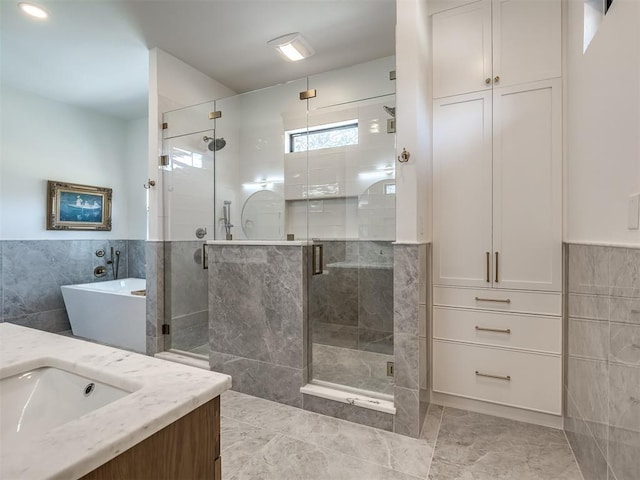 2320 Belleview Dr, Oklahoma City, OK 73112 - full bath featuring a soaking tub, vanity, tile patterned flooring, tile walls, and a stall shower