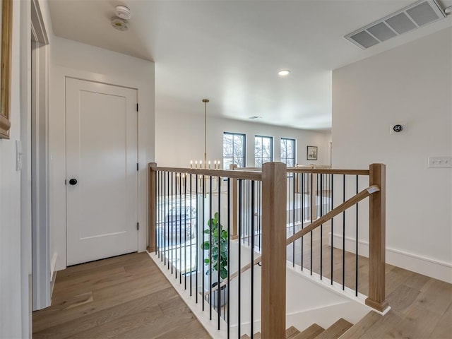 2320 Belleview Dr, Oklahoma City, OK 73112 - hall with an inviting chandelier, recessed lighting, an upstairs landing, visible vents, and wood finished floors