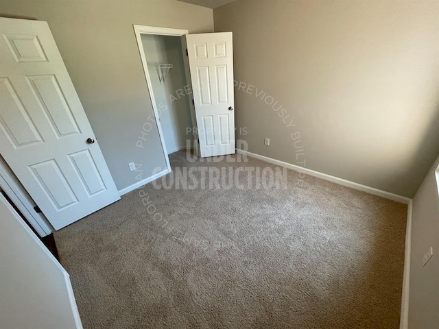 unfurnished bedroom with carpet floors, baseboards, and a closet