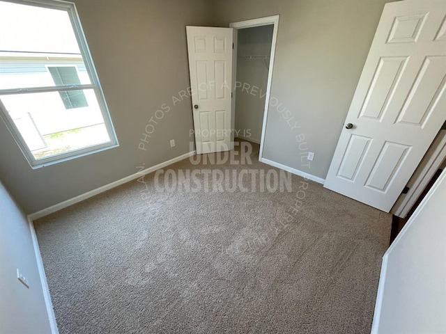 unfurnished bedroom with a closet, baseboards, and carpet