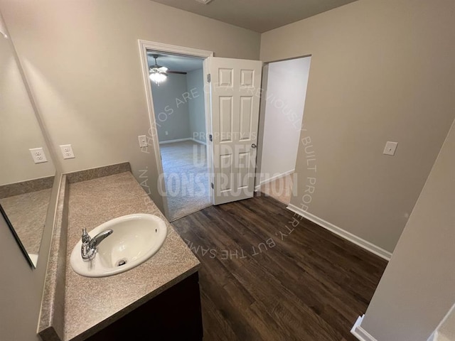 bathroom featuring baseboards, vanity, and wood finished floors